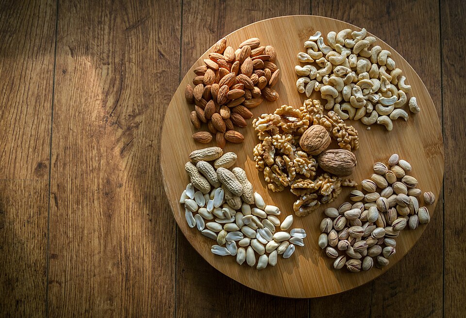 Almonds, cashews, walnuts, pistachios and peanuts on a wooden board